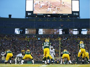 Quarterback Aaron Rodgers and the Packers line up against the Detroit Lions during game at Lambeau Field on Dec. 28, 2014 in Green Bay, Wisconsin.