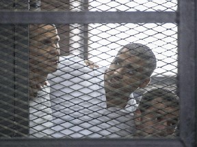 A file picture taken on June 23, 2014 at the police institute near Cairo's Tora prison, shows Al-Jazeera news channel's Australian journalist Peter Greste, Mohamed Fadel Fahmy and Baher Mohamed, listening to the verdict inside the defendants cage during their trial for allegedly supporting the Muslim Brotherhood.