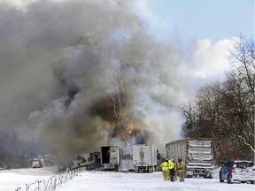 Emergency personnel watch as fireworks ignite at the scene of a fiery crash that closed both sides of Interstate 94, Friday, Jan. 9, 2015, between mile markers 88 and 92 in eastern Kalamazoo County, near Galesburg, Mich. State police say at least one person has died in the series of crashes involving roughly 150 vehicles, including at least two semi-trucks carrying fireworks and other hazardous materials. Authorities are blaming snow, wind and poor visibility in the crash.