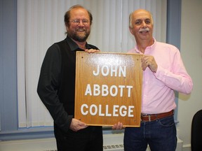 Erich Schmedt, academic dean at John Abbott (left), and retired teacher Gary Sims with the sign that had been "taken" 44 years ago.