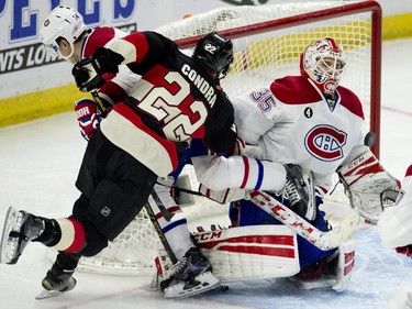 Montreal Canadiens goalie Dustin Tokarski makes a save as teammate defenseman Alexei Emelin and Ottawa Senators right wing Erik Condra crash into him during third- period action Thursday, Jan. 15, 2015, in Ottawa.