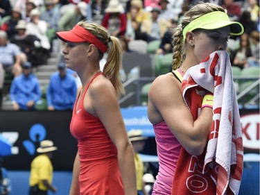 Eugenie Bouchard of Canada, right, and  Maria Sharapova of Russia change ends during their quarterfinal match at the Australian Open tennis championship in Melbourne, Australia, Tuesday, Jan. 27, 2015.