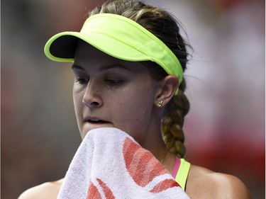 Eugenie Bouchard of Canada wipes the sweat from her face as she plays Maria Sharapova of Russia during their quarterfinal match at the Australian Open tennis championship in Melbourne, Australia, Tuesday, Jan. 27, 2015.