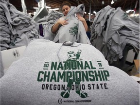 Katie Marie Snyder folds sweatshirts before packing them in boxes to be shipped from McKenzie Sew On in Springfield, Ore., to The Duck Store on the University of Oregon campus.