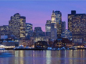 In this Jan. 6, 2012 file photo, the Boston city skyline is illuminated at dusk as it reflects off the waters of Boston Harbor. The U.S. Olympic Committee picked Boston on Jan. 8, 2015, as its bid city for the 2024 Summer Games.