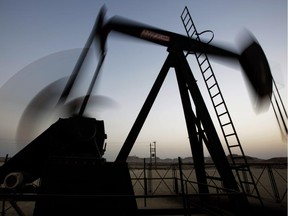 FILE - In this Oct. 14, 2014 file photo, an oil pump works at sunset in the desert oil fields of Sakhir, Bahrain. Global oil consumption has never been higher _ and it is rising. Yet the price of a barrel of oil has fallen by more than half over the past six months because the world, experts say, is awash in oil.