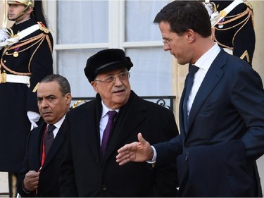 Dutch Prime Minister Mark Rutte (R) and Palestinian president Mahmud Abbas (C) leave the Elysee Palace before attending a Unity rally Marche Republicaine on January 11, 2015 in Paris in tribute to the 17 victims of a three-day killing spree by homegrown Islamists. The killings began on January 7 with an assault on the Charlie Hebdo satirical magazine in Paris that saw two brothers massacre 12 people including some of the country's best-known cartoonists, the killing of a policewoman and the storming of a Jewish supermarket on the eastern fringes of the capital which killed 4 local residents.