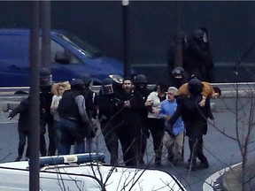 Members of the French police special forces evacuate the hostages after launching the assault at a kosher grocery store in Porte de Vincennes, eastern Paris, on January 9, 2015 where at least two people were shot dead on January 9 during a hostage-taking drama at a Jewish supermarket in eastern Paris, and five people were being held, official sources told AFP.