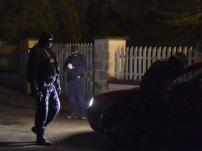 French police question a motorist at a road block in Longpont, northern France, on January 8, 2015, during searches as part of an investigation into a deadly attack the day before by armed gunmen on the Paris offices of French satirical weekly Charlie Hebdo. Reports this morning say the suspects in the massacre are surrounded by police in warehouse northeast of Paris.
