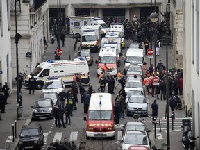 A general view shows firefighters, police officers and forensics gathered in front of the offices of the French satirical newspaper Charlie Hebdo in Paris on January 7, 2015, after armed gunmen stormed the offices leaving twelve dead. Heavily armed gunmen shouting Islamist slogans stormed a Paris satirical newspaper office on January 7 and shot dead at least 12 people in the deadliest attack in France in four decades. Police launched a massive manhunt for the masked attackers who reportedly hijacked a car and sped off, running over a pedestrian and shooting at officers.