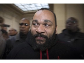 French controversial humorist Dieudonné Mbala Mbala arrives for a trial at the Paris courthouse on Dec. 13, 2013, on the charges of defamation, insults, incentive to hate and discrimination.