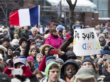 People hold up signs in Montreal, Sunday, January 11, 2015, during a solidarity rally in support of all the victims who lost their lives during terror related attacks in France.