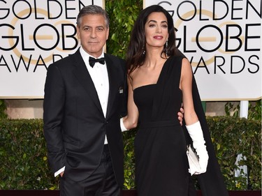 George Clooney, left, and Amal Clooney arrive at the 72nd annual Golden Globe Awards at the Beverly Hilton Hotel on Sunday, Jan. 11, 2015, in Beverly Hills, Calif. George is wearing a "Je suis Charlie" button.