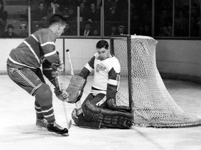 Young Detroit Red Wings goaler Glenn Hall, who  pioneered the butterfly style of goalkeeping, makes a save on Canadiens centre Jean Beliveau during a game at the Montreal Forum in the mid-1950s.