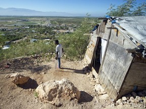 Maxi, age 22, stands near his home on a hill in Canaan, outside of Port au Prince, on Jan. 4, 2015, where he lives with his mother and a sister without electricity and water. Maxi's leg was amputated after he became trapped in the rubble of the Jan. 12, 2010, earthquake.