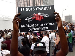 A man holds a placard that reads "Je suis Charlie, n'oublions pas les victimes de Boko Haram" (I am Charlie, let's not forget the victims of Boko Haram) as people gather outside the French embassy in Abidjan, on January 11, 2015, in tribute to the 17 victims of the three-day killing spree in Paris last week. The killings began on January 7 in Paris with an assault on the Charlie Hebdo satirical magazine in Paris that saw two brothers killing 12 people including some of the country's best-known cartoonists and the storming of a Jewish supermarket on the eastern fringes of the capital which killed 4 local residents.