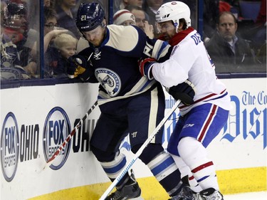 Columbus Blue Jackets' James Wisniewski, left, and Montreal Canadiens' David Desharnais work for the puck during the first period of an NHL hockey game in Columbus, Ohio, Wednesday, Jan. 14, 2015.