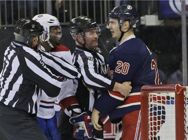 Linesmen Jay Sharrers (57) and Derek Nansen (70) separate New York Rangers left wing Chris Kreider (20) and Montreal Canadiens defenceman P.K. Subban (76) during the first period of the NHL hockey game Thursday, Jan. 29, 2015 at Madison Square Garden in New York.