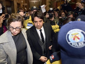 Jian Ghomeshi, centre, is surrounded by police and members of the media as he leaves court in Toronto on Thursday, Jan. 8, 2015.