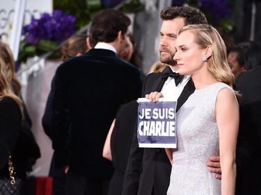 Joshua Jackson, left, and Diane Kruger pose with a sign reading "Je Suis Charlie" at the 72nd annual Golden Globe Awards at the Beverly Hilton Hotel on Sunday, Jan. 11, 2015, in Beverly Hills, Calif.