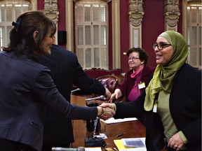 Quebec Minister of Immigration, Diversity and Inclusiveness Kathleen Weil (left) shakes hands with Samira Laouni, right, after she testified at a parliamentary commission at the Quebec legislature, Wednesday, Jan. 28, 2015.