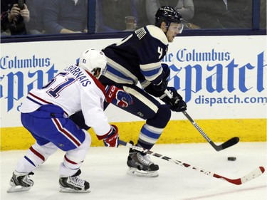 Columbus Blue Jackets' Kevin Connauton, right, works for the puck against Montreal Canadiens' David Desharnais during the third period of an NHL hockey game in Columbus, Ohio, Wednesday, Jan. 14, 2015. Montreal won 3-2.