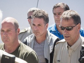 Left to right: Former Montreal, Maine & Atlantic Railway employees Thomas Harding, conductor for the train that derailed and exploded in Lac-Mégantic on July 6, 2013 killing 47 people, Jean Demaître, and Richard Labrie (in blue) arrive at a courthouse in Lac-Mégantic, 270 kilometres east of Montreal on Tuesday, May 13, 2014.