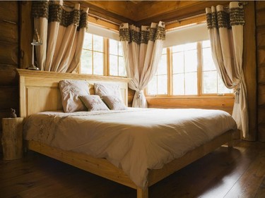 Large windows that occupy two walls in the master bedroom, provide lots of natural light which is diffused by the forest that surrounds the home.