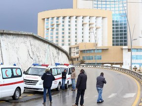 Libyan security forces and emergency services surround Tripoli's central Corinthia Hotel on January 27, 2015 in the Libyan capital. The hotel was reportedly attacked by Islamist gunmen today and gunfire was heard, an AFP photographer reported. According to security sources at the scene, four armed men had detonated a car bomb in front of the Corinthia Hotel, which is popular with foreigners, killing a guard, before rushing into the hotel.