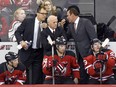 New Jersey Devils defensive coach Scott Stevens, left, and offensive coach Adam Oates, right, confer with general manager Lou Lamoriello behind bench during game against the Pittsburgh Penguins on Dec. 29, 2014, in Newark, N.J.