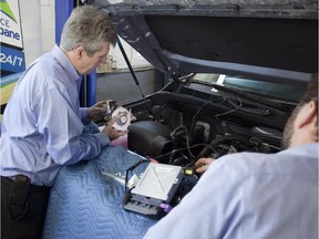 Mechanic Serge Brault works on the conversion of a vehicle to a propane-gasoline hybrid in this undated photo supplied in January 2015.