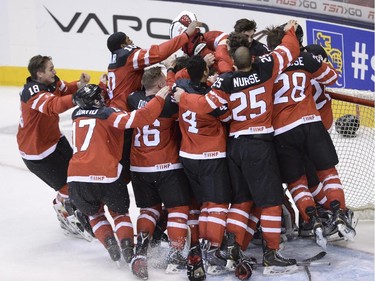 Members of Team Canada gather around goaltender Zachary Fucale to celebrate their gold-medal victory over Team Russia at the IIHF World Junior Championship in Toronto on Monday, Jan. 5, 2015.