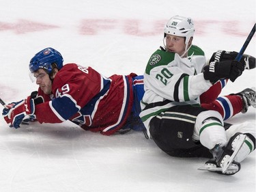 Dallas Stars' Cody Eakin and Montreal Canadiens' Michael Bournival fall to the ice after colliding during second period NHL hockey action Tuesday, January 27, 2015 in Montreal.