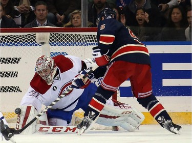 Carey Price (#31) of the Montreal Canadiens makes a first period save on Dan Girardi (#5) of the New York Rangers at Madison Square Garden on January 29, 2015 in New York City.