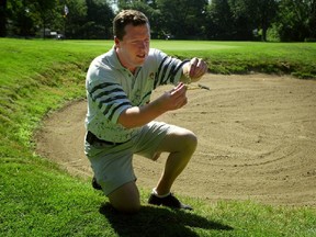 Dorval Municipal Golf Club manager Glenn Barrette has a closer look at some weeds on the golf course on July 3, 2002.
