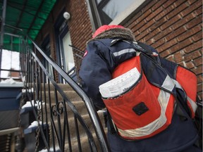 A Canada Post mailman delivers mail in the borough of Villeray–Saint-Michel–Parc-Extension in Montreal on Wednesday, December 11, 2013.