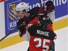 Team Canada's Darnell Nurse and Team USA's Brandon Carlo mix it up  during World Junior Hockey Championship game at the Bell Centre on Dec. 31, 2014. Canada won 5-3.