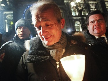 French consul general Bruno Clerc, left, walks towards the supporters while Mayor Denis Coderre looks on, right, during a vigil organized by Montreal City Hall on Wednesday night in support of the victims of the terrorist attack in Paris.