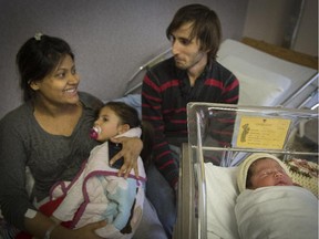 Rahela Akter, left, holding two-year-old daughter Bianca, with father Giovanni Naccarello, right, and Montreal's first born baby, Elsa Naccarello born 18 seconds into the new year at the Royal Victoria Hospital in Montreal, Thursday, January 1, 2015.