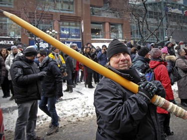 Helène Bergeron carries an over-sized pencil outside the French consulate as she joins thousands of Montrealers in a silent march Sunday January 11, 2015 in support of the victims of recent attacks in France.
