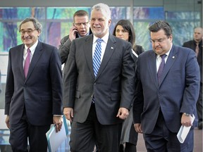 Quebec Premier Philippe Couillard, centre, Michael Sabia, President and CEO of the Caisse de dépot et placement du Québec and Montreal Mayor Denis Coderre, right, arrive for the announcement of an infrastructure partnership between the Caisse and the Quebec government, at the Caisse's headquarters in Montreal Tuesday January 13, 2015.