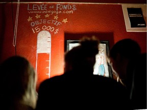 Customers pay the fee to attend a Levée de Son fundraiser at Divan Orange in Montreal's Plateau-Mont-Royal on Friday, Jan. 16, 2015. The club's aim was to raise $15,000 to cover fines incurred after neighbours complained about the noise.