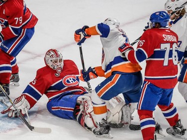 Montreal Canadiens goalie Dustin Tokarski falls as he makes a save against New York Islanders right wing Cal Clutterbuck during the second period at the Bell Centre on Saturday, Jan. 17.