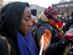 Auore Iradukunda, left, and Victor Bong at a vigil at Place Émilie-Gamelin on Sunday. The event was to remember victims of Boko Haram in Nigeria, and to show solidarity with families affected by atrocities there and in Cameroon.