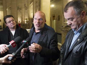 Marc Ranger, president of the Coalition syndicale pour la libre négotiation, centre, with the  president of Montreal's blue-collar workers union, Michel Parent, left, and Ronald Martin president of the Montreal firefighters union, speaks to reporters following  special Montreal council meeting on Monday January 19, 2015. The council meeting talked about the pension reform bill.