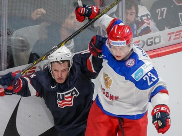 Team Russia forward Alexander Sharov, right, collides with Team USA forward Chase De Leo, left, during the second period of their 2015 IIHF World Junior Championship quarterfinal hockey match at the Bell Centre.