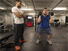 Under the watchful eye of  personal trainer Philip Hynes, Shaun Lydon  works out at the Fitness Factory in Dorval. Lydon has lost more than 150 pounds.