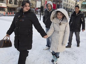 Anasztazia Szilagyi with her daughter Mercedesz, followed by son Mark  and her husband Dezso Nemeth, as they walk in downtown Montreal on Tuesday, Jan. 20, 2015.