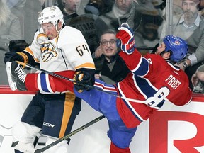 Montreal Canadiens Brandon Prust is knocked off balance by Nashville Predators Victor Bartley  during first period of National Hockey League game in Montreal Tuesday January 20, 2015.