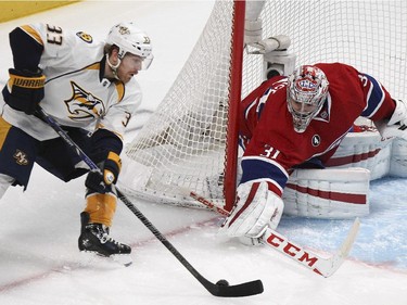 Montreal Canadiens goalie Carey Price reaches out to knock puck off Nashville Predators Colin Wilson's stick during second period of National Hockey League game in Montreal Tuesday January 20, 2015.